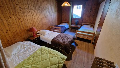 a room with two beds in a wooden cabin at Chalet l'Acinos in Montgenèvre