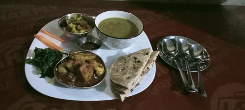 a plate of food with a bowl of soup and vegetables at Namaste Bardiya Resort in Bhurkīā