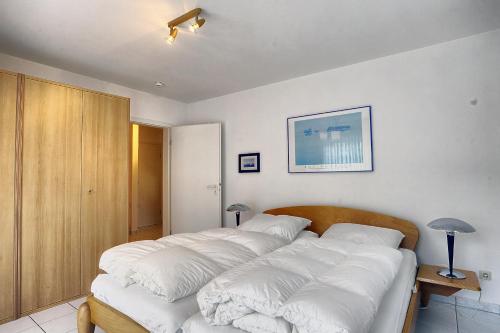 a bedroom with a large bed with white pillows at Strandkieker 13, PP innen in Zingst
