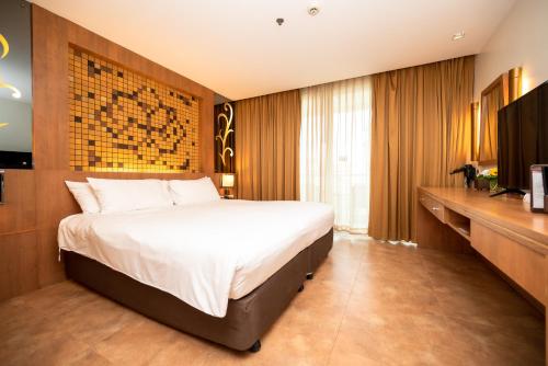 1 dormitorio con 1 cama grande y TV en Centara Nova Hotel Pattaya, en Pattaya central