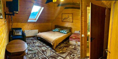 a bedroom with a bed in a wooden room at Під лісом у гіда in Yaremche