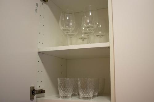 four wine glasses are sitting on a shelf at Ático con terraza en Cuesta Gomérez in Granada