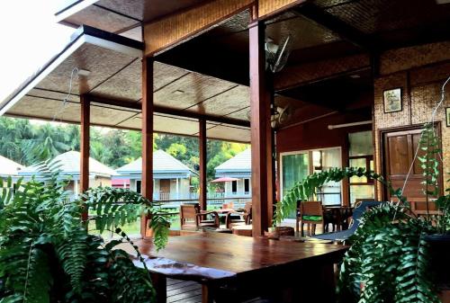 a patio with a wooden table and some plants at Jeerang Countryside Resort in Mae Hong Son