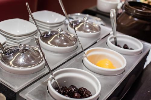 a tray with bowls of food on a table at Hotel Casa Poli in Mantova