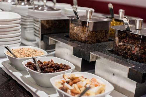 a buffet line with bowls of food and plates at Hotel Casa Poli in Mantova