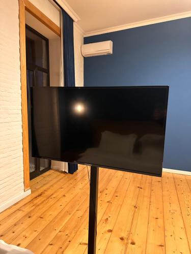 a flat screen tv sitting on a stand in a room at Apartment Riverside in Kutaisi