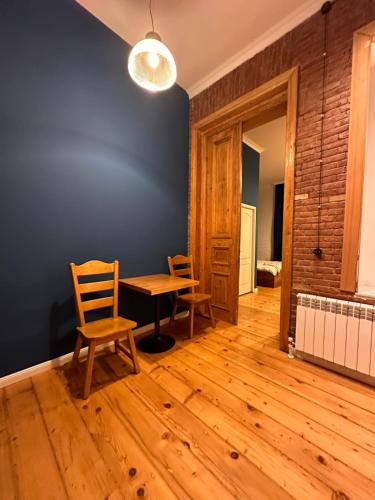 a room with a table and chairs and a blue wall at Apartment Riverside in Kutaisi