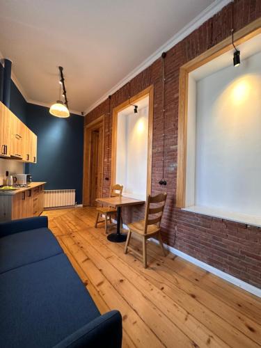 a living room with a table and a brick wall at Apartment Riverside in Kutaisi