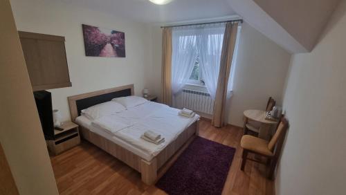 niewielka sypialnia z łóżkiem i oknem w obiekcie Hotel MONIKA w mieście Maków Mazowiecki