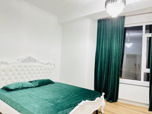 um quarto com uma cama com lençóis verdes e uma janela em Fabulous Penthouse 5* em Chisinau