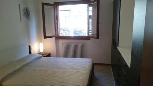 a bedroom with a bed and a window at Lakecomoweb Apartments in Perledo