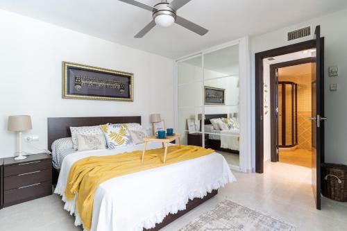una camera da letto con un letto e un ventilatore a soffitto di Playamar a Torremolinos