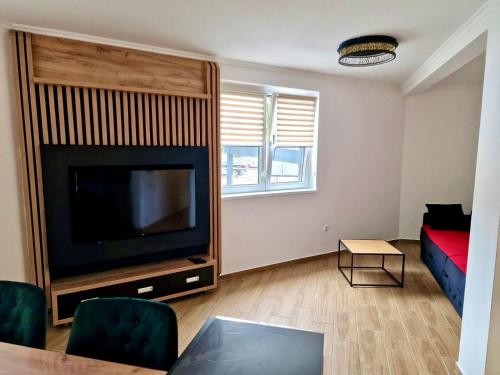 un salon avec une télévision à écran plat et un canapé dans l'établissement Sunčana Planina Kopaonik, à Kopaonik