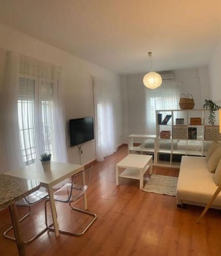 ein Wohnzimmer mit einem Sofa und einem Tisch in der Unterkunft Apartamento luminoso en Espartinas Totalmente climatizado in Espartinas