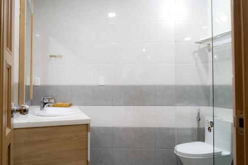 峴港的住宿－Bambu Hotel，浴室配有卫生间、盥洗盆和淋浴。
