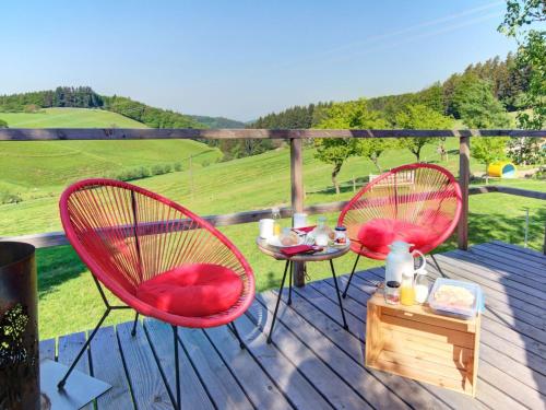 two red chairs and a table on a deck at Grub-Daniel-Hof in Freiamt