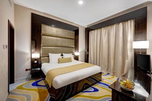 a hotel room with a bed and a television at Gevora Hotel in Dubai