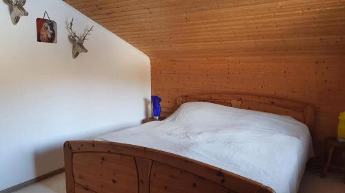 Bett in einem Zimmer mit Holzdecke in der Unterkunft Kleines Ferienhaus in Verditz
