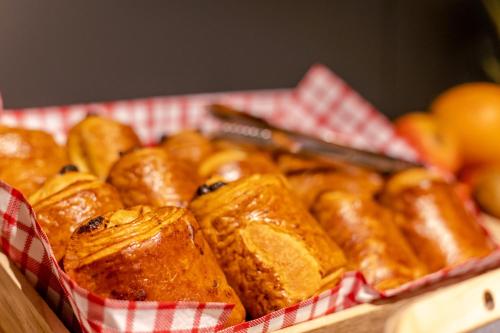 a basket filled with pastries and oranges on a table at Birgit Hôtel Le Havre Centre in Le Havre