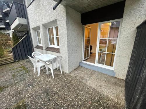 a patio with a table and chairs in front of a house at Joli studio au pied du Moleson in Gruyères
