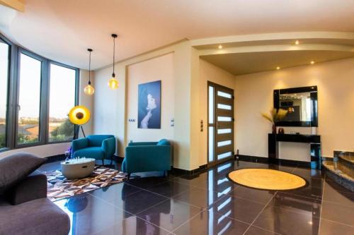 un soggiorno con sedie blu e un tavolo di Casa Grande Private Luxury Villa a Alykes Potamou