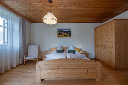 Schlafzimmer mit Holzbett und Holzdecke in der Unterkunft Erlebenswert Bauernhof Gruber in Sankt Lorenzen im Lesachtal