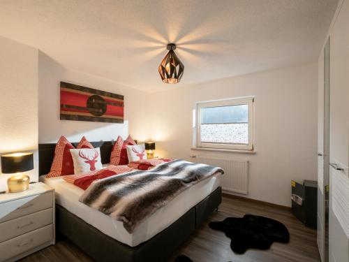 - une chambre avec un grand lit et des oreillers rouges dans l'établissement Haus Milan, à St. Johann in Tirol