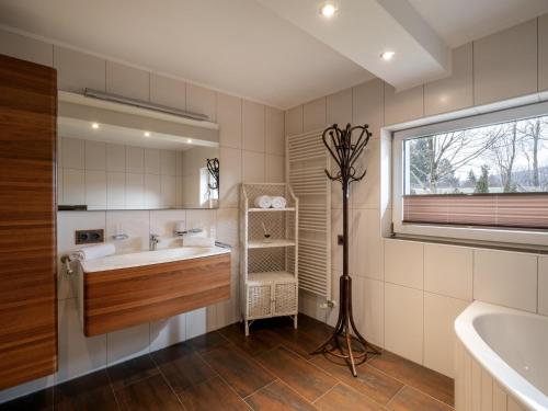 La salle de bains est pourvue d'une baignoire, d'un lavabo et d'une fenêtre. dans l'établissement Haus Milan, à St. Johann in Tirol