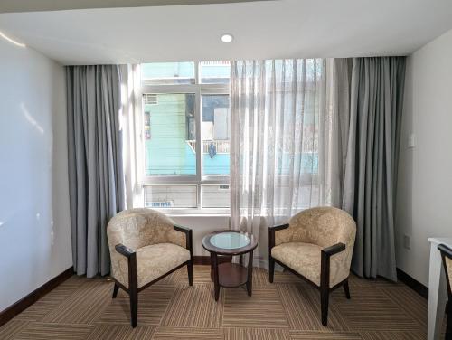 a room with two chairs and a table and a window at Đông Kinh Hotel in Ho Chi Minh City