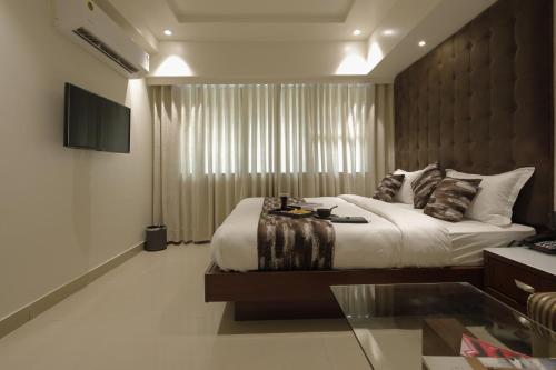 a bedroom with a large bed and a window at Hotel Ariana Residency in Mumbai