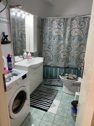 a bathroom with a washing machine and a toilet at Apartment Mitrou in Loutra Oraias Elenis 