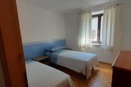 um quarto com duas camas e uma janela em Cà dei Zoani casa vacanze 022139 AT 722787 em Pergine Valsugana