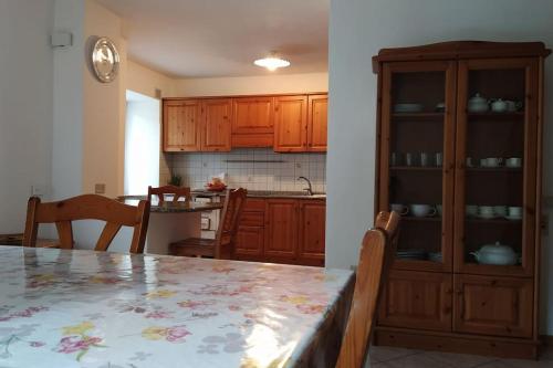 uma cozinha com armários de madeira e uma mesa com cadeiras em Cà dei Zoani casa vacanze 022139 AT 722787 em Pergine Valsugana