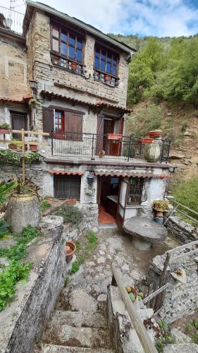 an old stone house with a balcony on a mountain at Characteristic house Aquasanta in Lecchiore