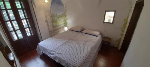 a bedroom with a bed in a room with windows at Characteristic house Aquasanta in Lecchiore