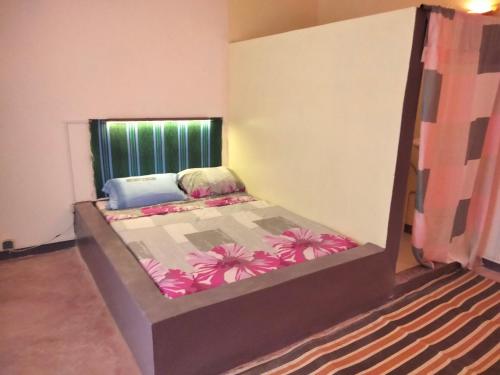 um quarto com uma cama num quarto com uma janela em Gaal-Gui, chez Guillaume em Mboro