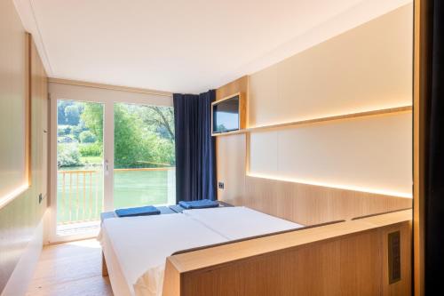 ein Schlafzimmer mit einem Bett und einem großen Fenster in der Unterkunft Boutique Boatel Attila in Muntelier