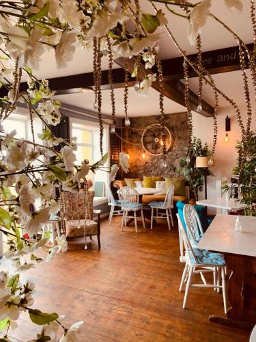 a room with a table and chairs and white flowers at Harbour House Inn Newcastle, Northern Ireland in Newcastle
