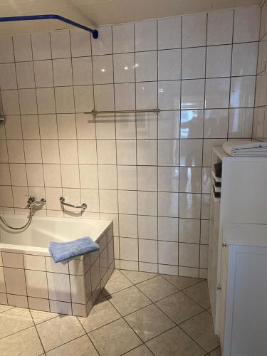 een badkamer met een bad en een blauwe handdoek bij Ferienwohnung Schanz in Konken