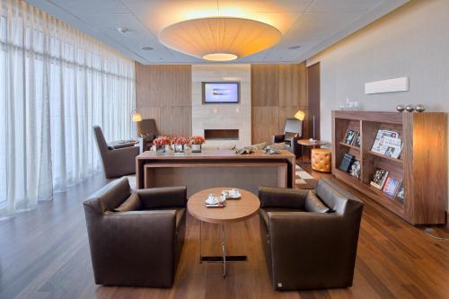 a living room with chairs and a table in a room at EPIC SANA Lisboa Hotel in Lisbon