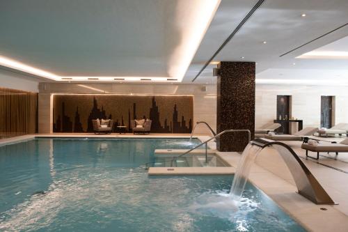 a pool in a hotel with chairs and a swimming pool at EPIC SANA Lisboa Hotel in Lisbon