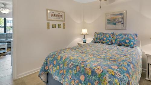 a bedroom with a bed with a colorful comforter at Hidden Beach 117 in Santa Rosa Beach