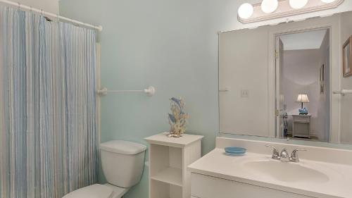 La salle de bains est pourvue de toilettes, d'un lavabo et d'un miroir. dans l'établissement Hidden Beach 117, à Santa Rosa Beach