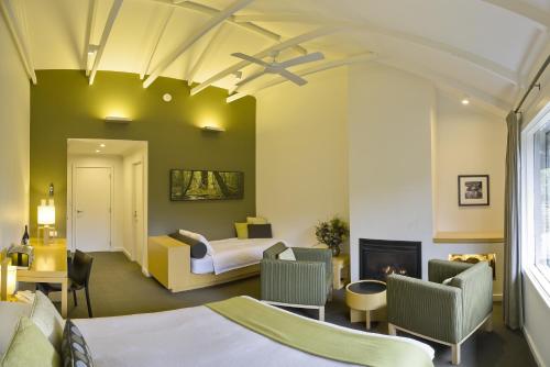 a hotel room with two beds and a fireplace at Peppers Cradle Mountain Lodge in Cradle Mountain