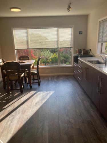 a kitchen with a table and chairs and a window at Private Guest House in Mapua