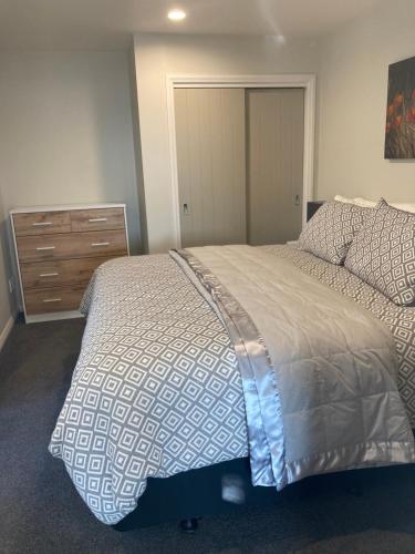 a bedroom with a large bed and a dresser at Private Guest Suite in Mapua