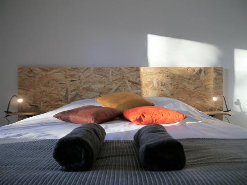 a bed with four pillows on it with a headboard at Appartement Le Céleste 113 - deux chambres in Ramonville-Saint-Agne