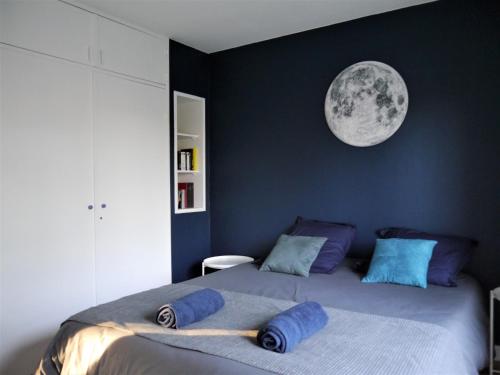 - une chambre avec un grand lit et une lune sur le mur dans l'établissement Appartement Le Céleste 113 - deux chambres, à Ramonville-Saint-Agne