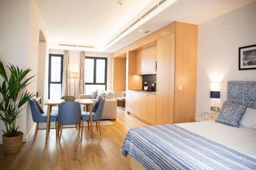 ein Hotelzimmer mit einem Bett und einem Tisch und Stühlen in der Unterkunft nQn Aparts & Suites Sevilla in Sevilla