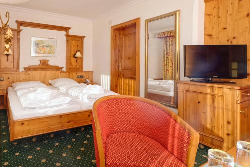 a bedroom with a bed and a flat screen tv at Ortnerhof - Ihr Zuhause am Fuße der Alpen in Ruhpolding